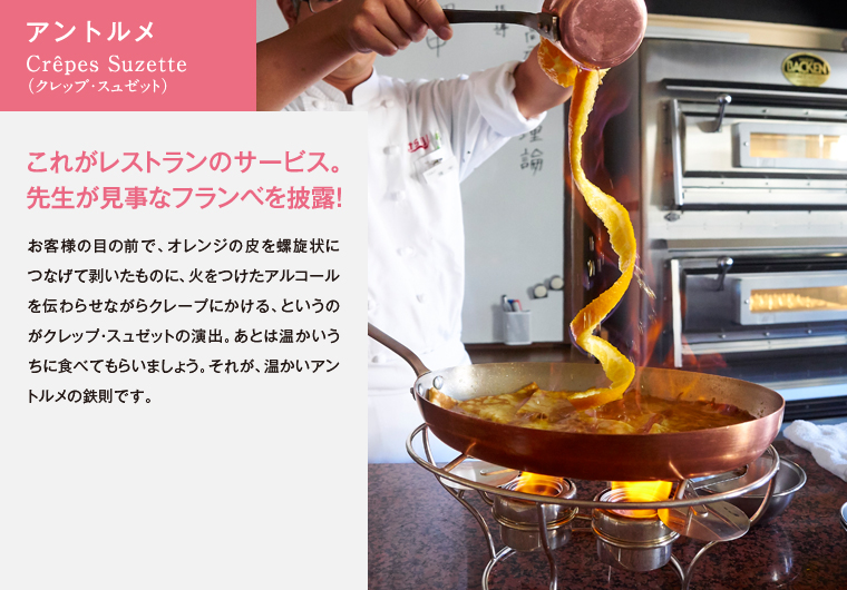 アントルメ　Crêpes Suzette（クレップ・スュゼット）　これがレストランのサービス。先生が見事なフランベを披露！　お客様の目の前で、オレンジの皮を螺旋状につなげて剥いたものに、火をつけたアルコールを伝わらせながらクレープにかける、というのがクレップ・スュゼットの演出。あとは温かいうちに食べてもらいましょう。それが、温かいアントルメの鉄則です。