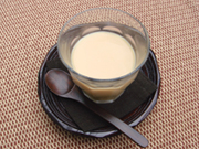 日本茶で使う茶托（大ぶりのもの）に茶色い布製のコースターを敷き、厚手のガラスコップに熱いチャイを注ぎます。木製のスプーンで温かみを出しました。